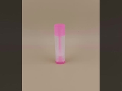 Pequena embalagem lisa e clara de bálsamo labial com tampa rosa para batons