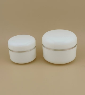 Pote de creme de plástico branco com bordas arredondadas e borda prateada para loção feminina