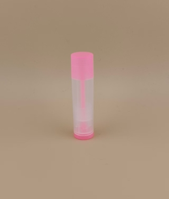 Pequena embalagem lisa e clara de bálsamo labial com tampa rosa para batons
